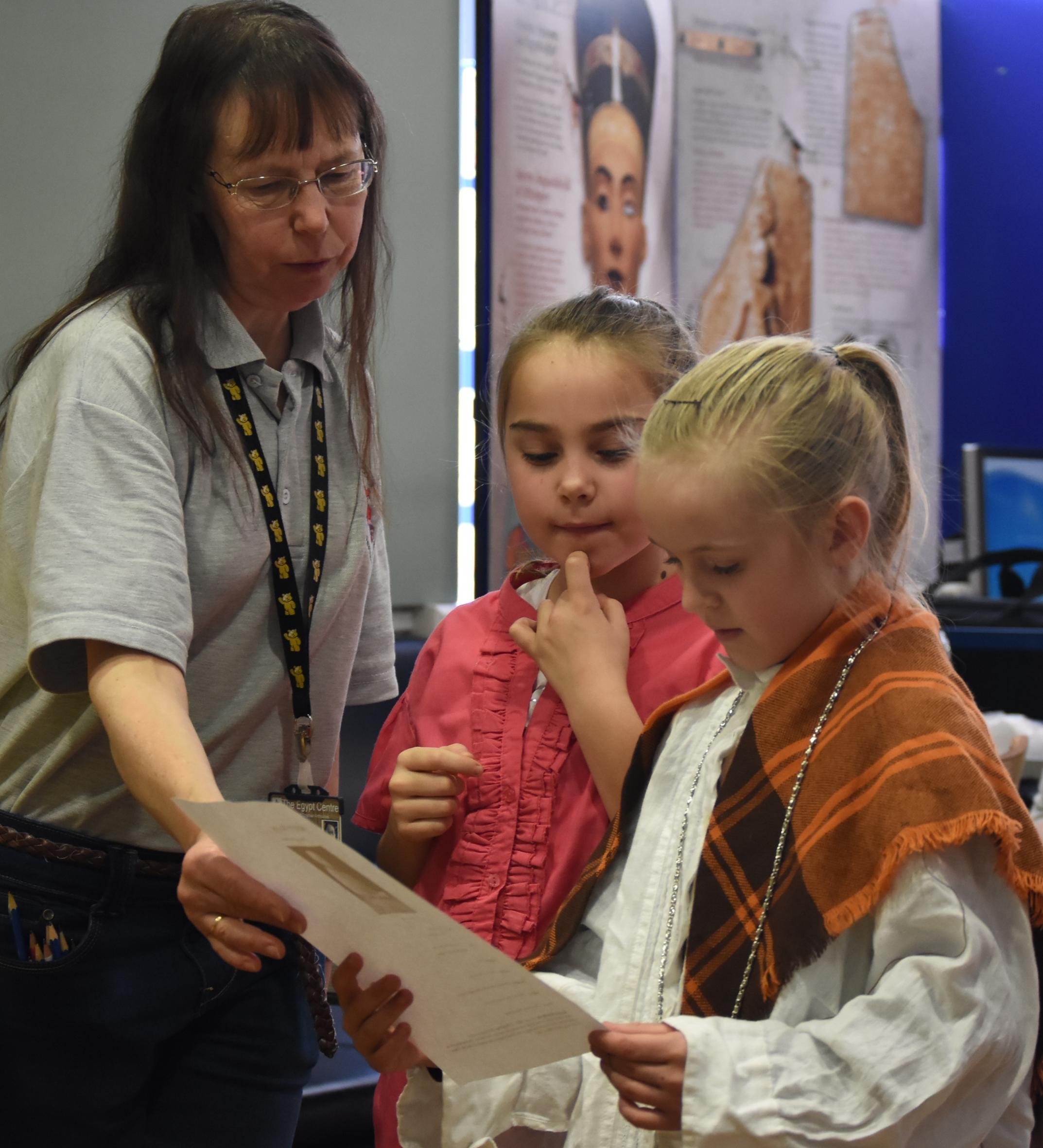 Alison John, Workshop Leader, helping read role play cards with children
